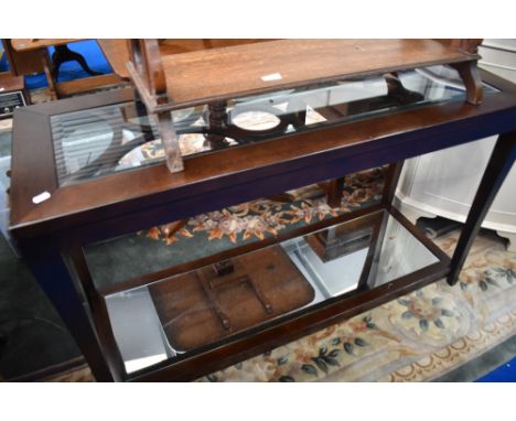 A modern hardwood console table having glass top and mirror base