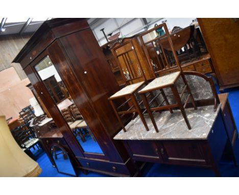 An Edwardian mahogany bedroom suite comprising mirror door wardrobe, dressing table, wash stand and two bedroom chairs