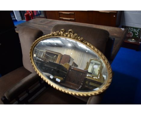 An oval wall mirror having bow decoration