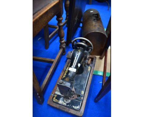 A vintage singer sewing machine in dome top wood case