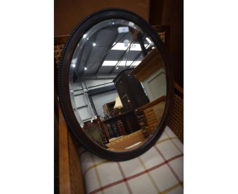 An early 20th Century oak oval wall mirror