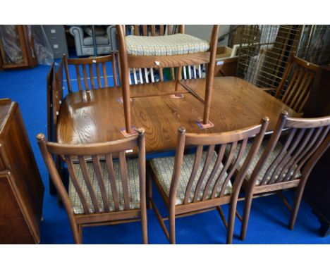 A modern Ercol dining room table, extending , with three additional leaves and eight (six plus two) railback chairs, in mid s