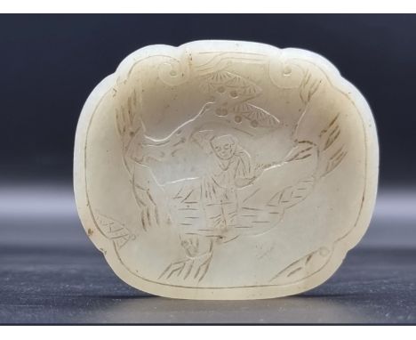 A Chinese pale celadon jade lid,&nbsp;carved in shallow relief with a figure in landscape, 7.5 x 6.5cm. 