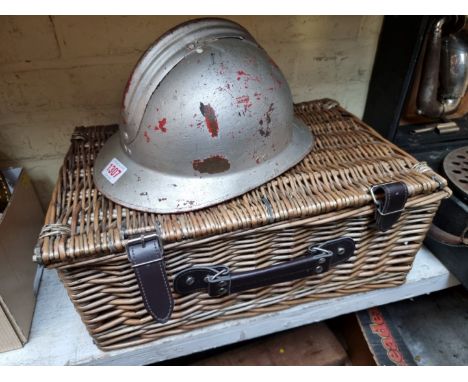 A vintage French tin helmet,&nbsp;together with a small picnic hamper.&nbsp; 