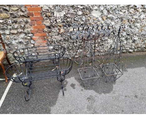 A wrought iron planter;&nbsp;together with a pair of black painted planters and a pair of plant obelisks.&nbsp; 