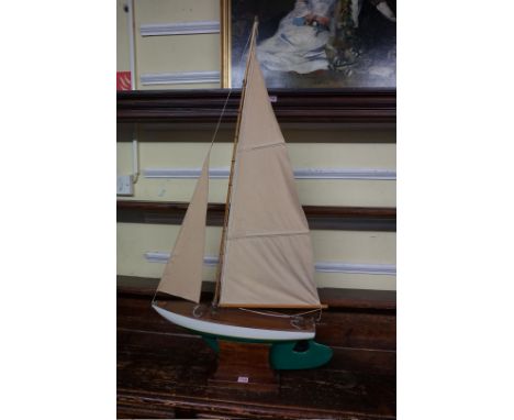 A vintage pond yacht,&nbsp;the hull 56.5cm long, on mahogany stand. 
