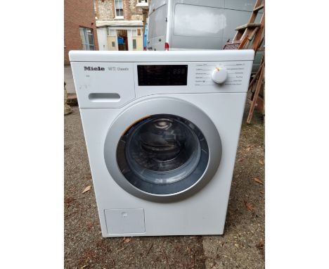 A Miele W1 classic washing machine, 84.5cm high x 60cm wide, with instruction manual. 