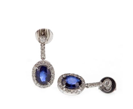 PAIR OF SAPPHIRE AND DIAMOND EARRINGS, each set with an oval sapphire within a round brilliant cut diamond halo, suspended fr