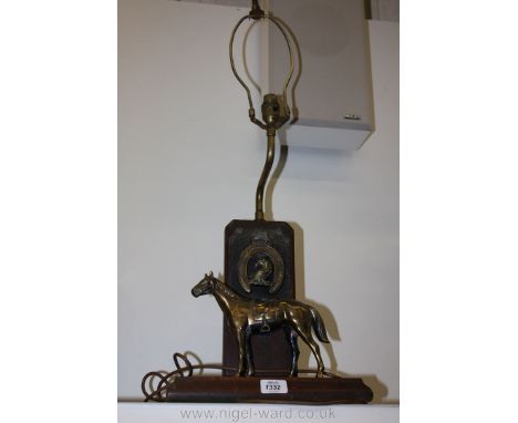 A Brass horse Lamp on wooden stand.