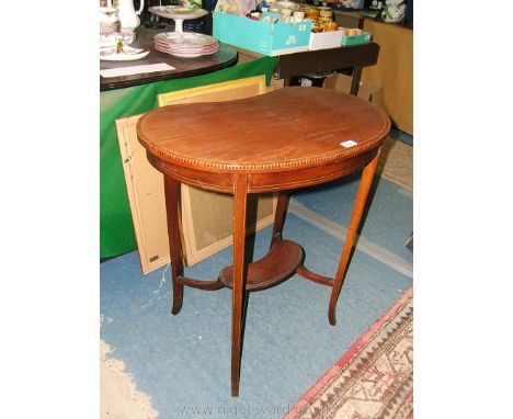 An Edwardian Mahogany kidney shaped occasional Table, the shaped top with strung border and light and dark inlaid edge, on tw