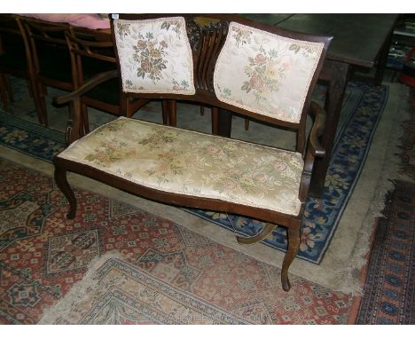 An Edwardian Mahogany salon Sofa, with curved top rail over double pad back with central fret-cut, pierced splat, serpentine 