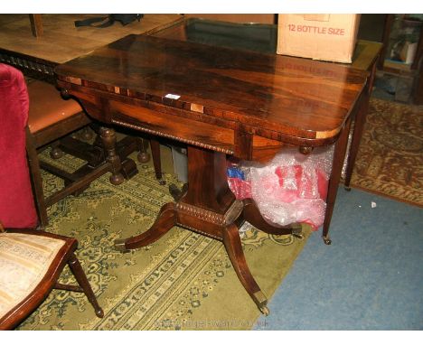 An elegant Regency Rosewood fold-over Card Table, the fold over rotating top opening to reveal blue baize gaming surface, on 