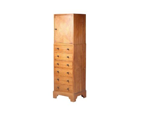 A Gordon Russell Workshops English walnut tallboy, design no 674, c 1928, with a single veneered cupboard above six graduated