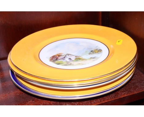 Three Crown Derby wall plates with yellow borders, centres painted landscapes by W E J Dean, an Aynsley Bermuda Islands plate