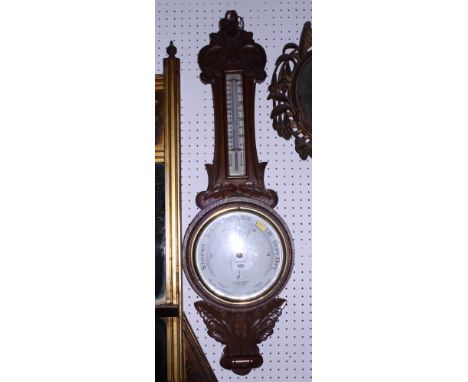 A Dolland aneroid barometer, in carved oak case