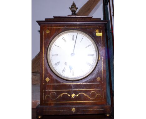 A Regency mahogany mantel clock with brass inlay decoration, the brass 'pineapple' finial raised on a carved stepped base wit