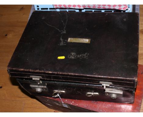 A green leather vanity case with part fitted silver vanity items including a silver topped glass spirit flask with removable 