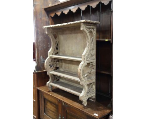 An 18th century carved and painted pine four-tier open wall shelf, 27" wide