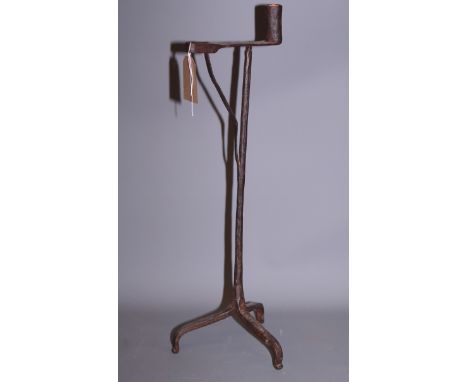 A wrought iron rush light holder/candlestick, on tripod base, 23" high