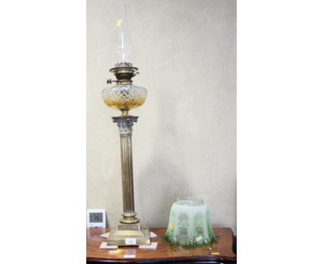 A late 19th century brass Corinthian column oil lamp with cut glass reservoir etched green glass shade, 36" high overall