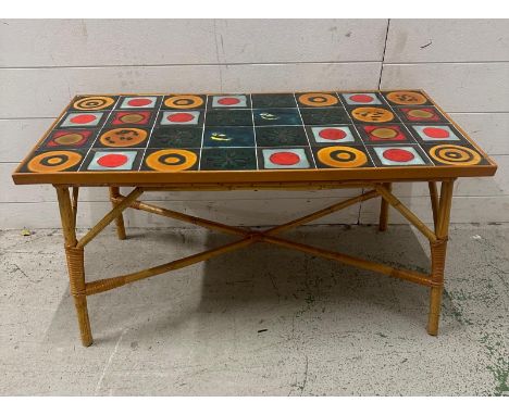 A Mid Century multi coloured tile topped table on bamboo legs (H43cm W89cm D45cm)