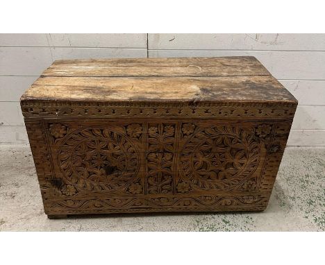 A vintage pine trunk or coffer with heavily carved front (H47cm W80cm D44cm)