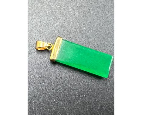 A Jade pendant set with 18ct gold plate.