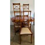 A Bradley veneered extendable pedestal dining table on brass lions paw feet and seven chairs (