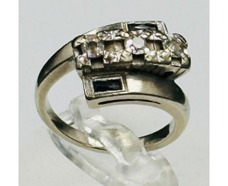 A 14ct white gold contemporary diamond and sapphire ring in a crossover style, approximate weight 6.3g.