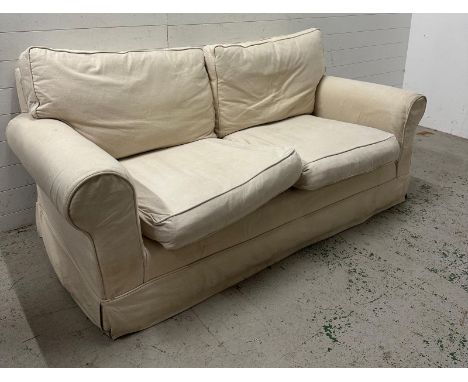 A cream two seater sofa with removable covers