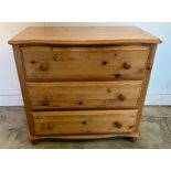 A pine three drawer chest of drawers on bun feet (H72cm W79cm D46cm)