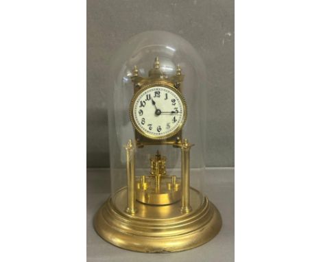 A continental 19th Century brass Torsion clock with enamel face and glass dome 