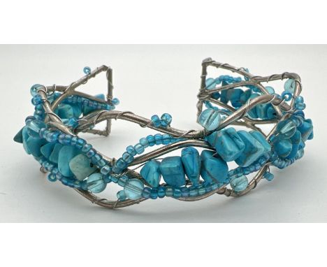 A white metal twisted design cuff bangle set with turquoise chips &amp; small blue glass beads. 