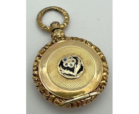 An Edwardian 9ct gold overlay locket with enamelled floral design &amp; engine turned detail. Central flower detail to front 