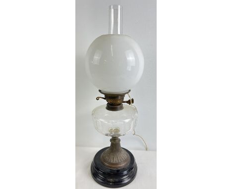 A vintage oil lamp with faceted clear glass bowl, white glass shade, chimney and stepped ceramic base. Has been converted to 