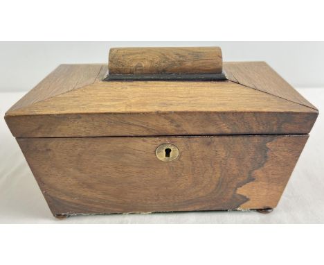 An antique sarcophagus shaped wooden tea caddy with bun feet and brass escutcheon. 2 interior lidded compartments. Approx. 22