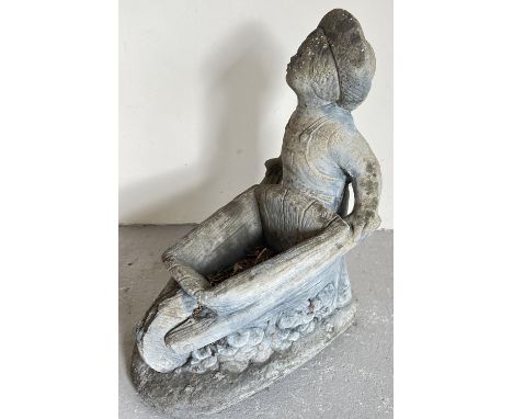 A large concrete garden planter modelled as a boy pushing a wheel barrow. Approx. 55cm tall x 40cm long. 