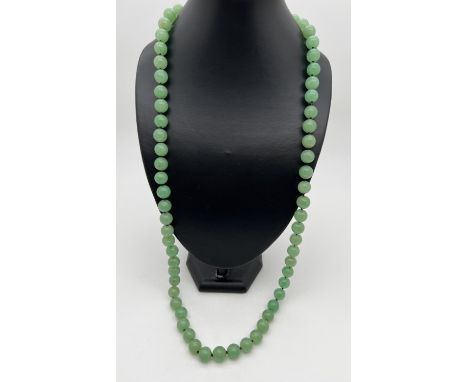 A 33" string of apple green jade beads, knotted between each bead. Beads approx. 1.2cm diameter. 