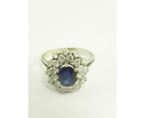 A SAPPHIRE AND DIAMOND CLUSTER RING, IN WHITE GOLD, MARKED 750, 6.1G