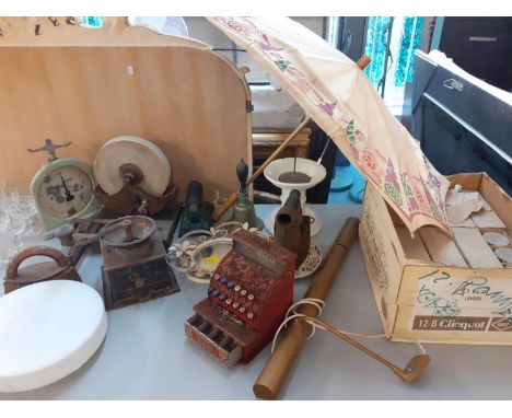 A vintage kitchen and household lot to include a knife sharpener, a bell, a football clacker, a mirror, a trivet, a parasol, 