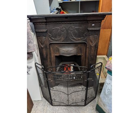 A Victorian cast iron fireplace with swag ornament with a later mantel 