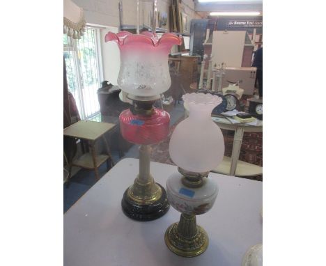 A Victorian brass column oil lamp with cranberry reservoir and an etched shade, along with a small Victorian brass oil lamp w