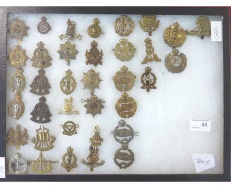 Glazed and mounted display of 36 Corp Regiment cap badges in Reconnaisance Corp, Army Educational Corp, Army Medical Corp, Mi
