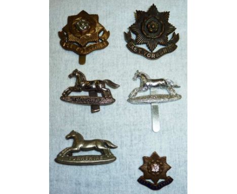 2 East Yorkshire regimental cap badges and a brass and enamel East Yorkshire lapel badge and 3 PWO badges