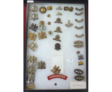 Mounted in glazed display of a collection of Manchester Regimental badges inc shoulder titles, buttons etc, inc Oldham, Manch