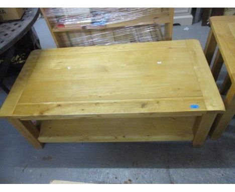 A modern light oak, two tier, coffee table, raised on square legs, 18" h, 47" w 