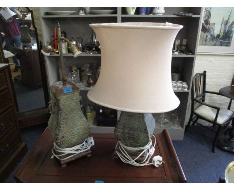 A pair of Eastern metallic urn style table lamps, together with a single cream lamp shade