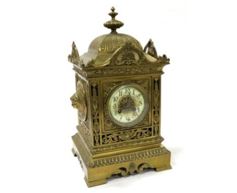 A Gilt Metal Striking Mantel Clock, circa 1900, domed pediment with a central finial, side masks, pierced borders, enamel Ara