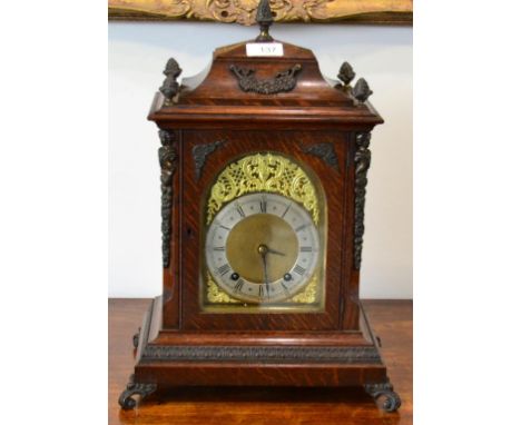 An Oak Quarter Striking Mantel Clock, circa 1900, caddied pediment with acorn finials, side sounds frets, scroll feet, Roman 