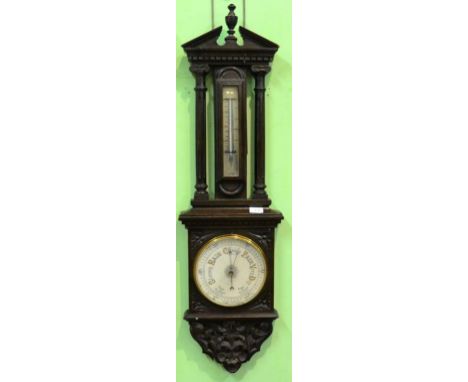 An Oak Aneroid Barometer, circa 1900, broken arched pediment, thermometer tube, 8-inch pottery dial, carved borders, 108cm hi